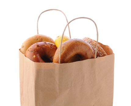 Closeup of a brown paper bag filled with a variety of different bagels. Bagels include: onion, blueberry, egg and multi-grain. Horizontal format isolated on white. 