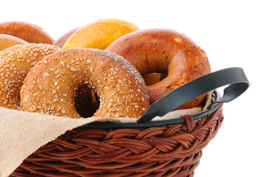 Closeup of assorted fresh bagels in a basket, including egg, sesame seed, multi-grain, plain, and cinnamon raisin.
