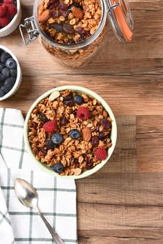 A bowl of Granola cereal with fresh fruit. Vertical with copy space.