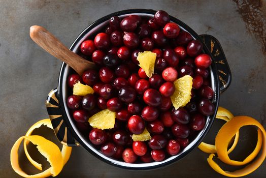 A pot full of fresh cranberries and orange pieces. High angle view of the traditional Thanksgiving holiday side dish.