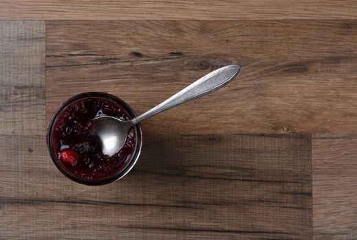 Fresh Homemade Cranberry Sauce and Spoon on a wood kitchen table. 