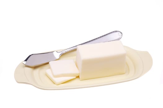 Stick of Butter and Knife on Plate with two pats cut isolated over white