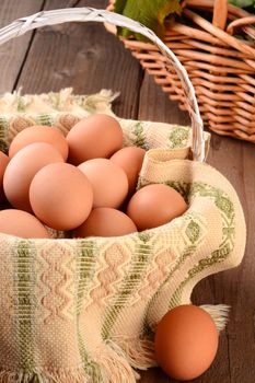 Closeup of a basket full of brown eggs in a rustic farmhouse like setting. Horizontal format with shallow depth of field.