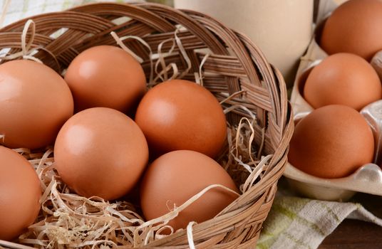 Closeup of a basket full of brown eggs in a rustic farmhouse like setting. Horizontal format with shallow depth of field.