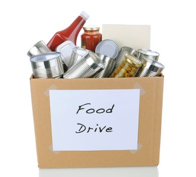 A box full of canned and packaged foodstuff for a charity food donation drive. Isolated on white with reflection.