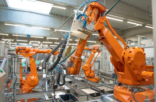 orange robot arms on the production line. controlled by a computer with artificial intelligence.