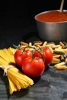 Ingredients for an Italian Style meal with copy Space. Vertical format on black.