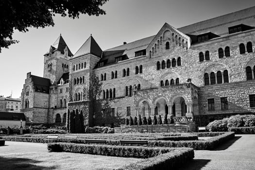 A historic stone imperial castle with a garden in Poznan, black and white