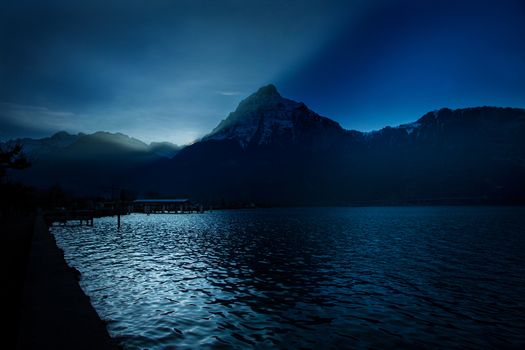 Sunset in swiss mountains with shadows and reflection in lake Lucerne