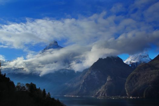 clouds and mountains with a lake in foreground near Brunnen in Switzerland