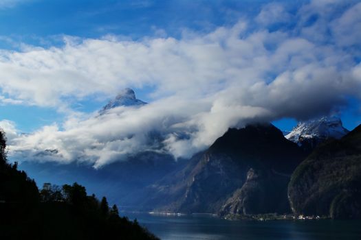 clouds and mountains with a lake in foreground near Brunnen in Switzerland
