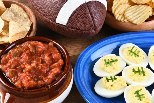 Closeup of snacks for watching a football game, chips, salsa and deviled eggs. Great for Super Bowl or Playoff themed projects.