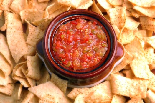 Top view of a bowl filled with salas surrounded by corn chips. Focus is on the dip.