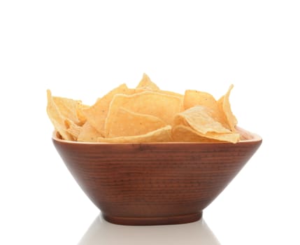 Closeup of a wood bowl filled with corn chips. Isolated on white with reflection.