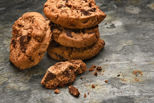 Closeup of a stack of chocolate chip cookies on a slate surface. Horizontal format with copy space.