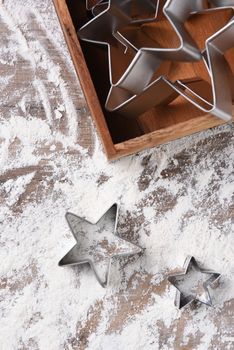 Star shaped cookie cutters on floured table.