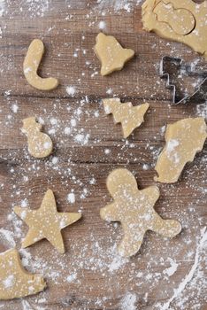Holiday Cookie shapes on a floured wood kitchen table. 