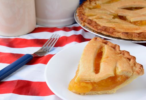 A slice of fruit pie on an American Flag table cloth. 