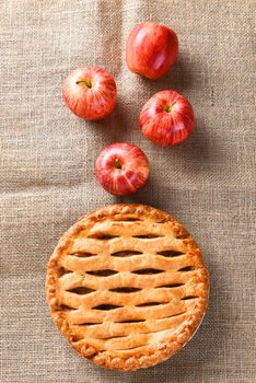High angle view of a fresh baked apple pie for the Thanksgiving holiday, Vertical format on a burlap surface.