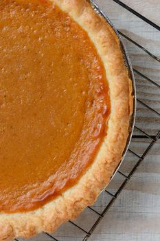 Closeup of a fresh baked pumpkin pie on a cooling rack ready for a Thanksgiving feast.