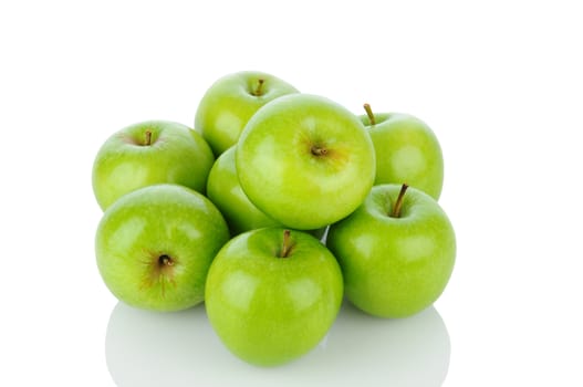 A pile of Granny Smith apples on white with reflection. Horizontal format.