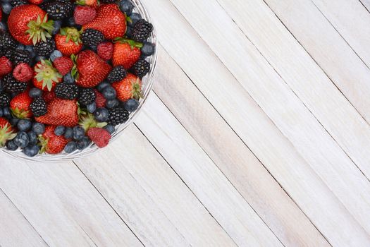 High angle shot of a basket of fresh picked berries in the upper left corner of the frame. Horizontal format with copy space.