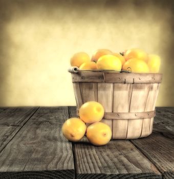 Fresh ripe lemons in a basket on a rustic wood table. Square format with faded look.