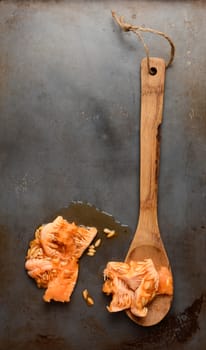 High angle shot of a wood spoon and the seeds and pulp scooped from a cantaloupe. Overhead view in vertical format with copy space.