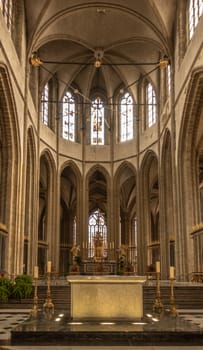 Dunkerque, France - September 16, 2018: Inside Saint Eloi church shows chancel with high ceiling and two altars. Brown environment. Light through high windows.