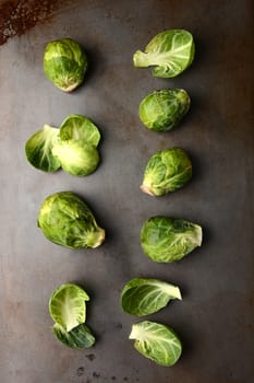 Brussels sprouts arranged on a metal cooking sheet, vertical format