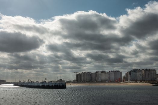 Oostende, Flanders, Belgium - September 18, 2018: Heavy cloudscape over wall of condominium buildings along beach, often called Atlantic Wall. Old Staketsel on the left. Shot from Western sea barrier.