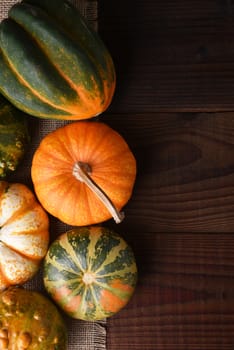  Autumn Gourds and decorative pumpkins on dark wood table.