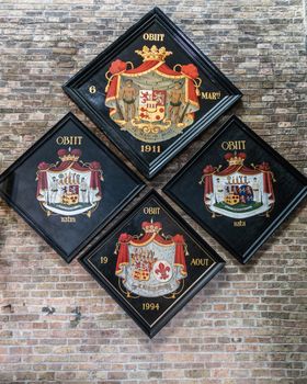 Brugge, Flanders, Belgium - September 19, 2018: Four colorful Family coat of arms on brick wall in Jerusalem Church of Bruges.