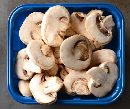 Closeup of a tub of sliced mushrooms. 