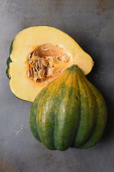 High angle view of an Acorn Squash cut in half on a metal baking sheet.