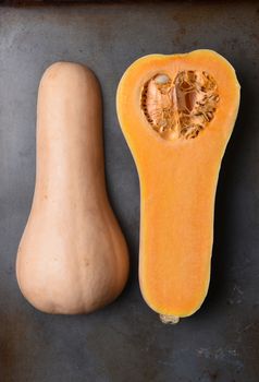 High angle view of a Butternut Squash cut in half on a metal baking sheet.