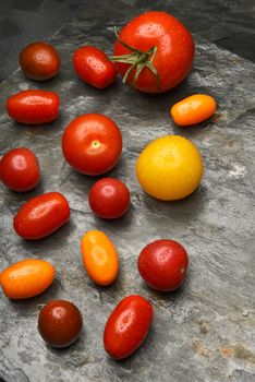 Top view of a group of medley tomatoes on a slate table.