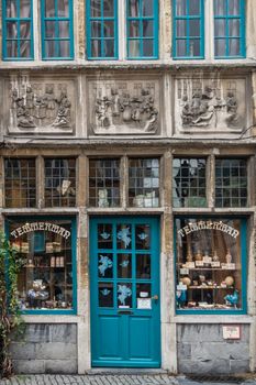 Ghent, Belgium - September 23, 2018: Historic Temmerman candy store in Kraanlei. Azure window frames, gray-beige cement frescos and walls. Pots with candy on display.