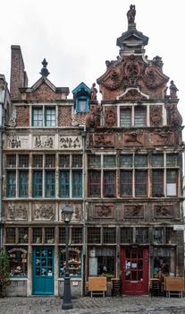 Ghent, Belgium - September 23, 2018: Seven Works of Mercy house and the Flutist house in Kraanlei are two medieval houses with fresco decorated facades. First is now candy store, second a Thai restaurant.
