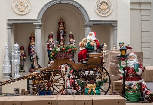 Antwerp, Belgium - September 24, 2018: Santa Claus mannequin in carriage display surrounded by smaller one and Christmas gifts in store on Meir.