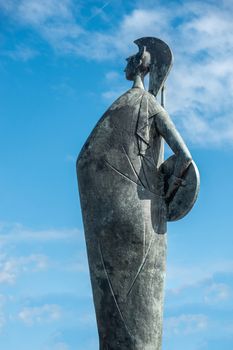 Antwerp, Belgium - September 24, 2018: Bronze Goddess Minerva statue by Marcello Mascherini under blue sky with some white clouds on Steenplein, border of Scheld River.