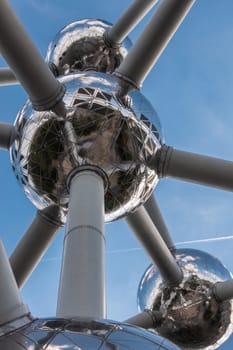 Brussels, Belgium - September 25, 2018: Closeup of four silver shining spheres of the voluminous Atomium monument and tubes against blue sky.