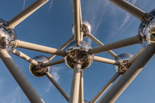 Brussels, Belgium - September 25, 2018: Closeup of six silver shining spheres of the voluminous Atomium monument and tubes against blue sky.