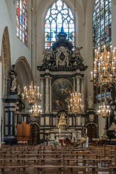 Brussels, Belgium - September 26, 2018: High Altar of Cathedral of Saint Michael and Saint Gudula with chandeliers, stained glass windows, chairs and statues.
