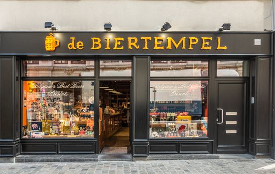 Brussels, Belgium - September 26, 2018: De Biertempel most famous Belgian beer and merchandise shop downtown. Yellow sign on black frame. Colorful display windows.