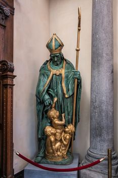 Brussels, Belgium - September 26, 2018: Inside Saint Nicolas Church. The saint saves children, enslaved by Muslims. Statue of green and gold.