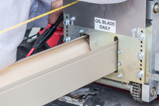 Worker Measuring Rain Gutter Processing Through Seamless Shaping Machine.