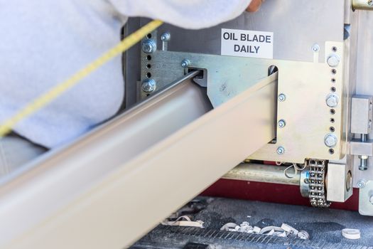 Worker Measuring Rain Gutter Processing Through Seamless Shaping Machine.