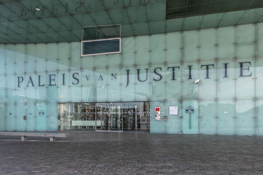 Amsterdam, the Netherlands - June 30, 2019: Entrance to and greenish glass wall with huge blue lettering spelling out Justice Palace in Dutch on IJdok.