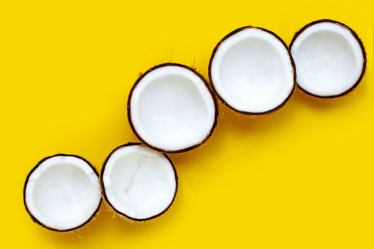 Half coconuts on yellow background. Copy space